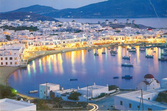 Image of the island Naxos in Greece, shoreline of several white buildings lit up by the sea